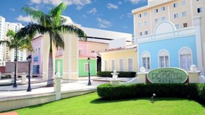 A hotel with a sign reading "PREMIER HOTEL" in a well-maintained courtyard with a palm tree and a fountain. - Hotel Premier (São Luís)
