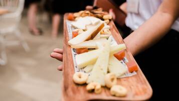 Un plateau en bois contenant divers fromages et amuse-gueules.
