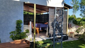 Ein Patio mit Holztable und -stühlen, umgeben von einem weißen Zaun.