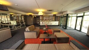 A modern lobby with seating areas, a reception desk, and large windows. - Villa Four Rooms (Kharkiv)