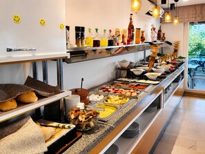 Un bufé con diferentes opciones de comida, una máquina de café y una estación para prepararlo.