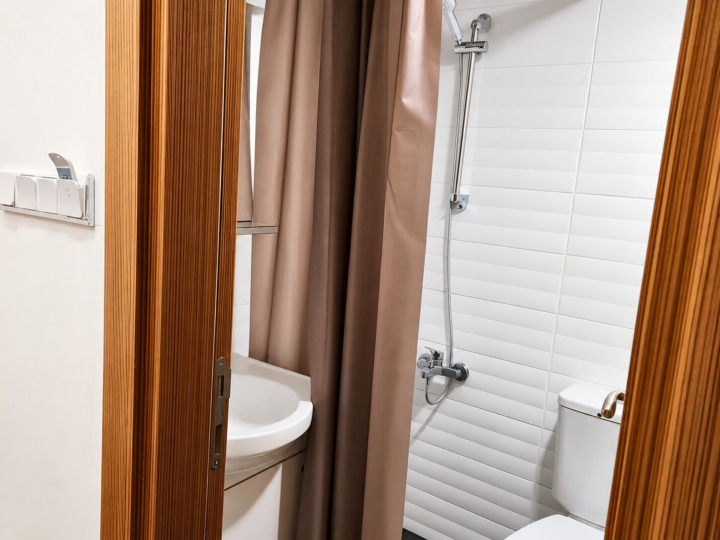 A bathroom with a white sink, a shower, and a toilet.