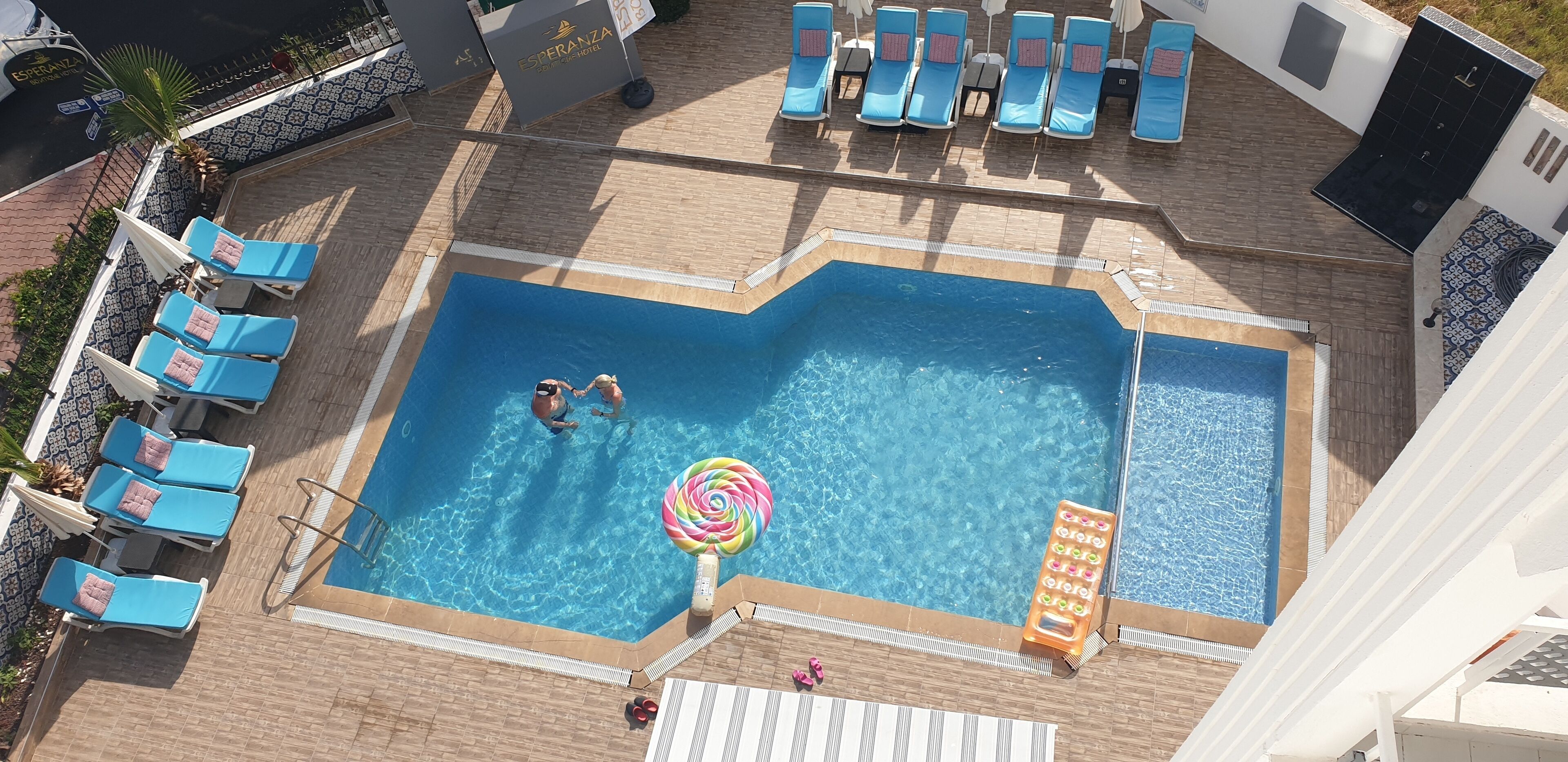 Una piscina al aire libre, sombrillas, sillones reclinables de piscina