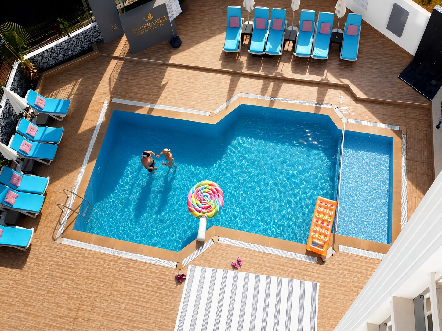 Piscina com espreguiçadeiras e posto de salva-vidas.