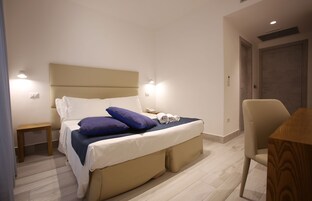 Un dormitorio moderno con cama, mesita de noche y una silla.