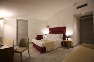 Una habitación de hotel moderna con una cama grande, un escritorio y una silla.