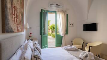 Une chambre d’hôtel avec un lit, une chaise, une télévision et un tableau au mur.