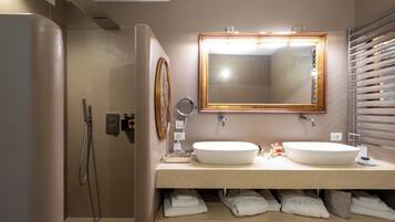 Un baño con lavamanos doble, un espejo grande, ducha y toallero.