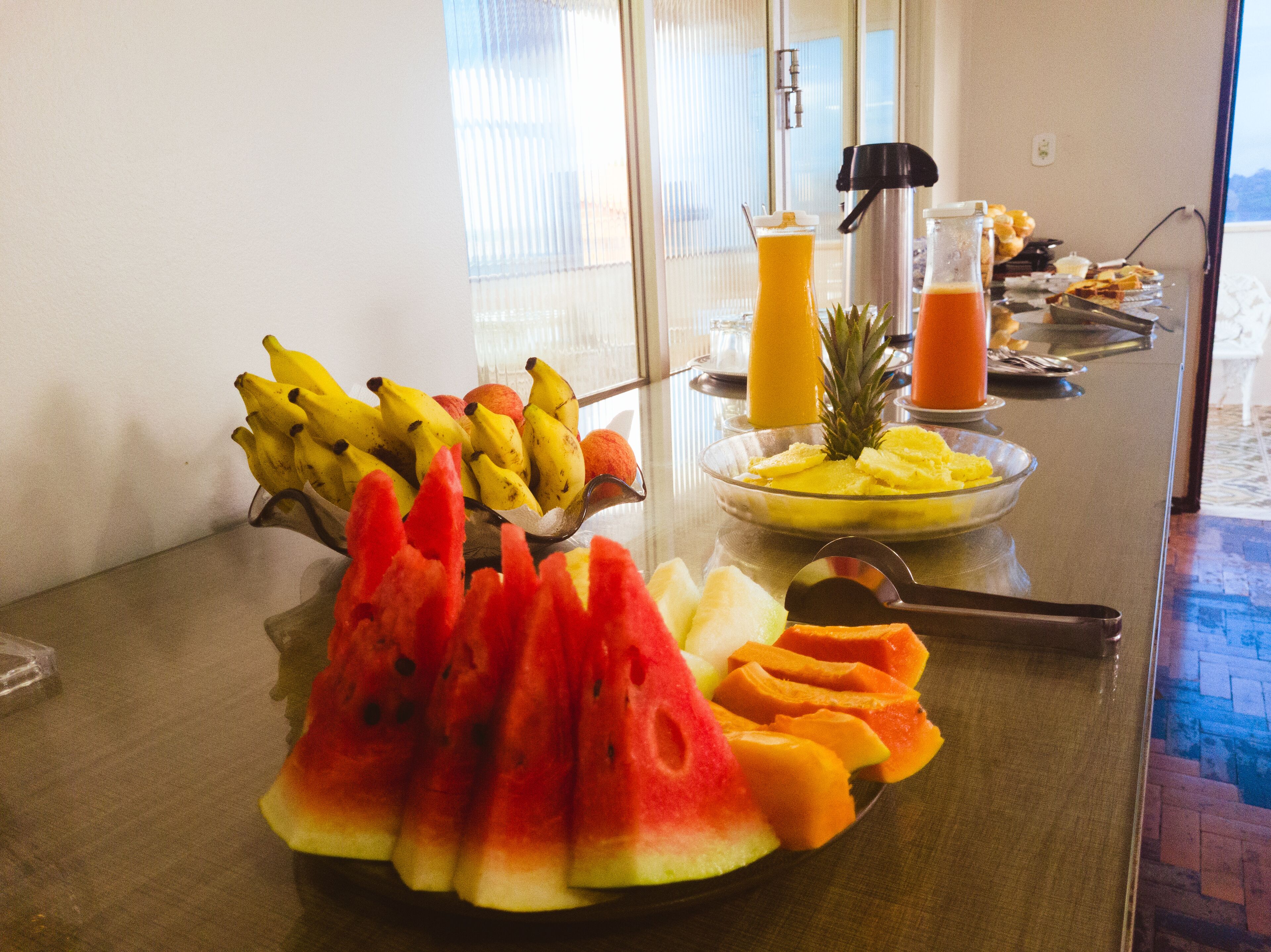 A breakfast buffet with various fruits and beverages.