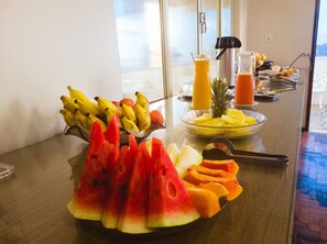 A breakfast buffet with various fruits and beverages. - Hotel Itatiaia (São Luís)