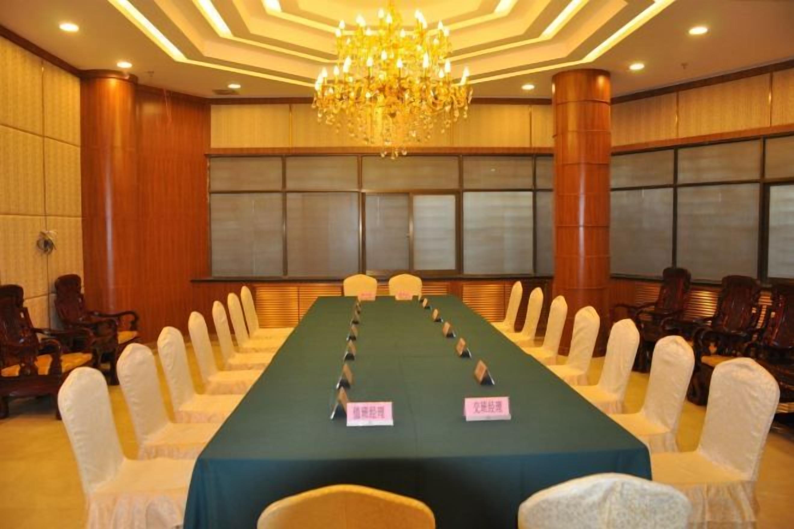 A conference room with a long table, chairs, and a chandelier.