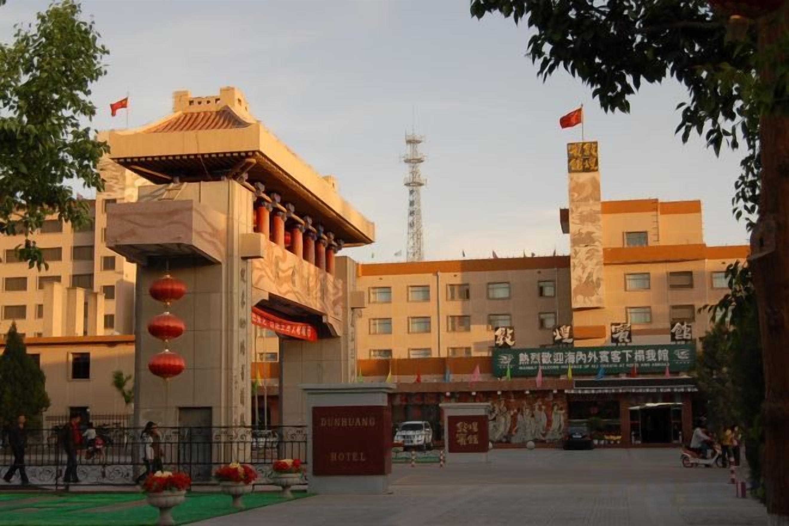 A hotel with a traditional architectural style, a prominent entrance, and a signboard.