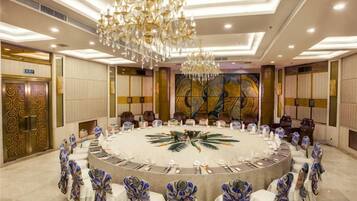 A conference room with a round table, chairs, and a chandelier.