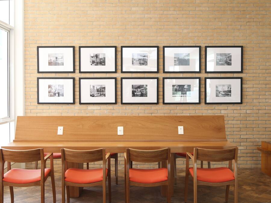 A room with a brick wall, a wooden bench, and a table with chairs.
