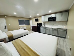 A hotel room with two beds, a kitchenette, a TV, and a window. -  AC Suites NJ (Atlantic City)
