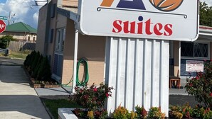 Un letrero de hotel con un logotipo y la palabra 'suites'.