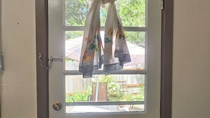A door with a chain lock and a window with curtains. - Cedar Lodge Motel (Dunsmuir)