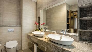 Une salle de bain moderne avec deux lavabos, des toilettes et un grand miroir.