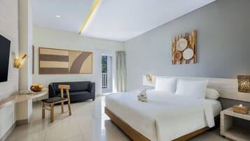 Una habitación de hotel moderna con una cama grande, un escritorio, un sofá y un televisor.