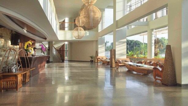 Un'ampia hall con soffitto alto, ampie finestre e una scalinata centrale.