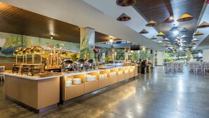 Un'area buffet con diverse postazioni gastronomiche, un affresco sulla parete e un soffitto con lampade a sospensione.
