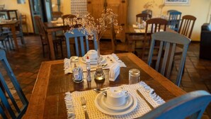 Una mesa puesta con platos, cubiertos y un jarrón de flores.
