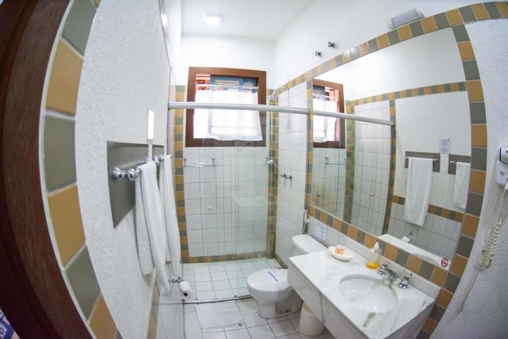 A compact bathroom with a shower, toilet, and sink.