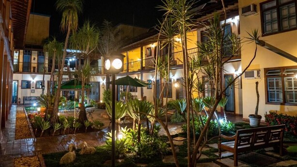 Un patio con piscina, palmeras y un banco.