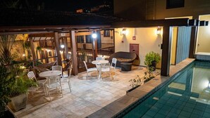 Zona junto a la piscina con mobiliario exterior y piscina.