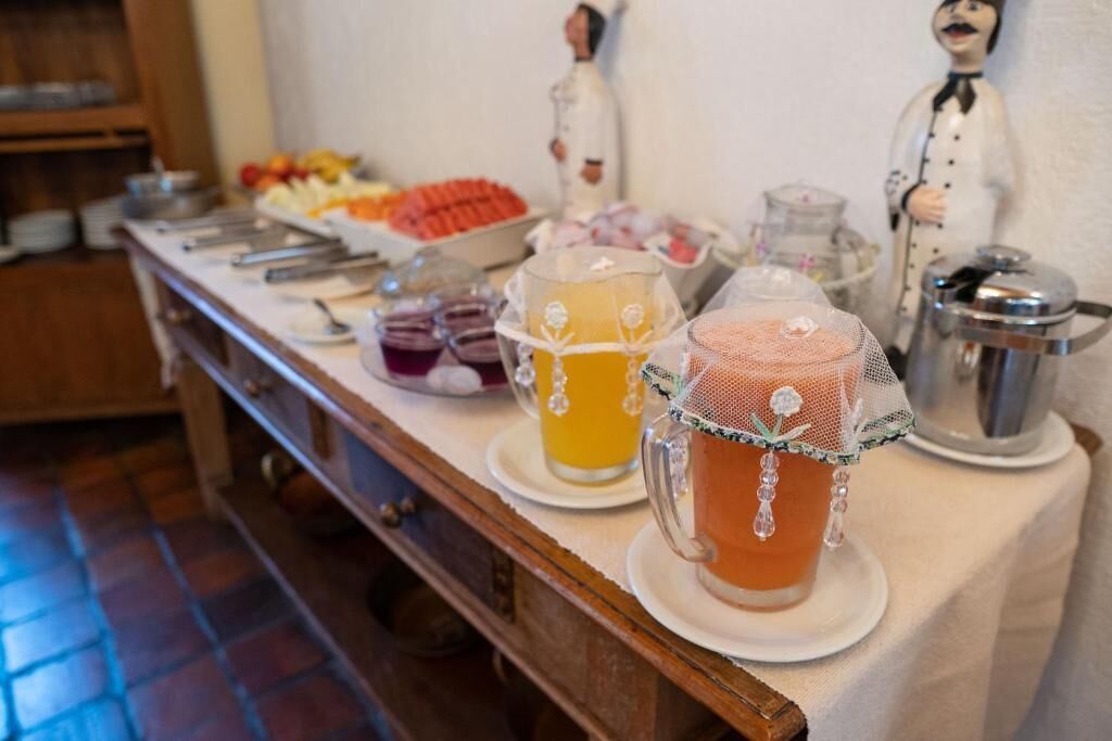 A buffet table with various food items and beverages, including a fruit platter, a coffee station, and a juice bar.