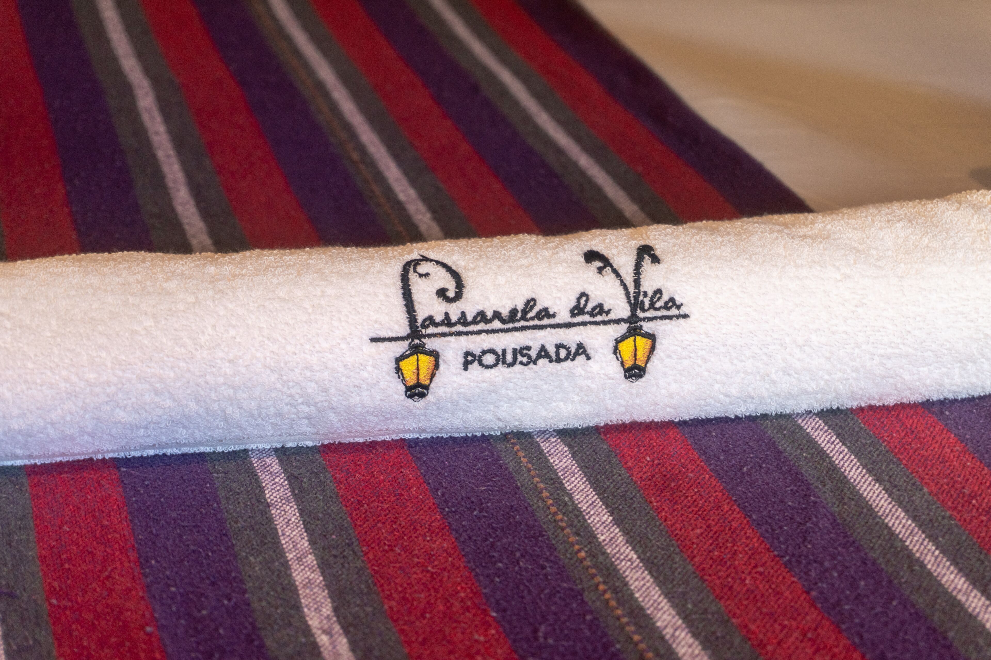 A towel with embroidered text and a logo.