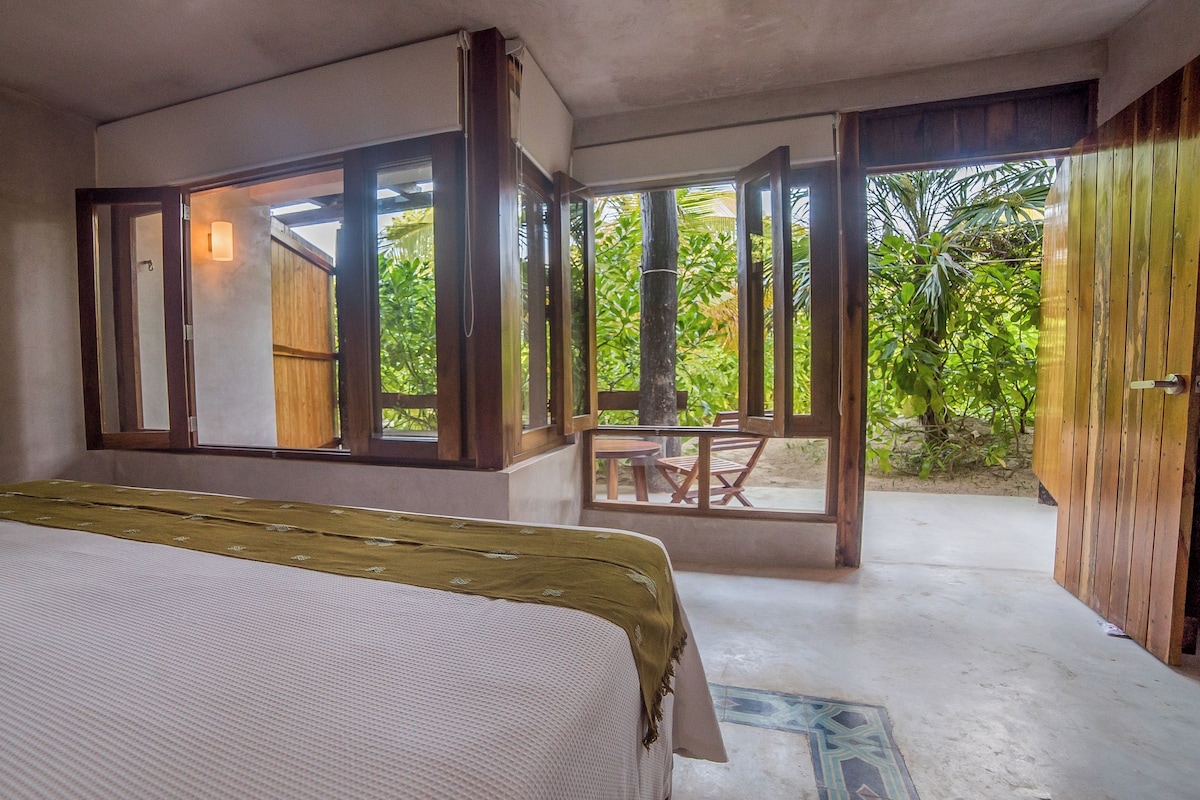 A bedroom with a bed, a window, and a view of the outdoors.