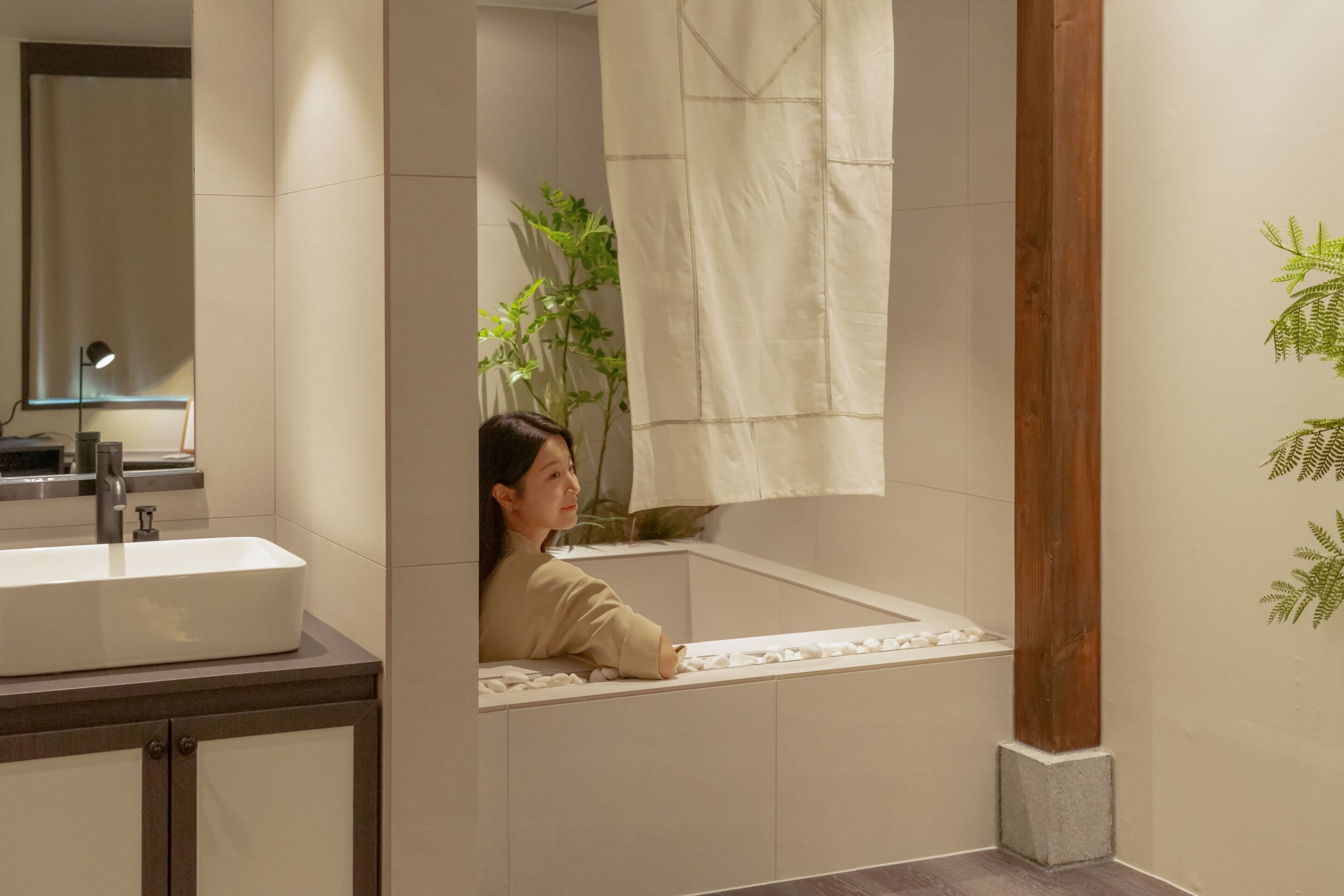 A bathroom with a sink, mirror, and a towel hanging on the wall.