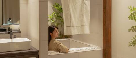 A bathroom with a sink, mirror, and a towel hanging on the wall.
