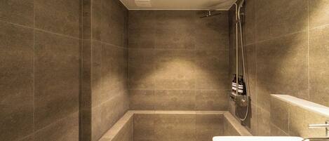 A modern bathroom with a walk-in shower, a bathtub, and a sink.