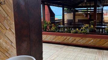 A covered outdoor area with a tiled floor, a table, and chairs.