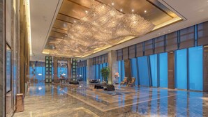 A spacious lobby with a reflective marble floor, a large chandelier, and seating areas. - Wanda Vista Zhengzhou (Zhengzhou)