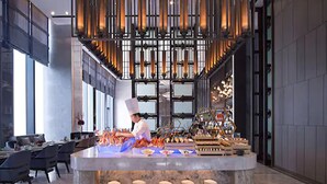 Een modern restaurantinterieur met een kok die eten bereidt aan een centraal eiland.