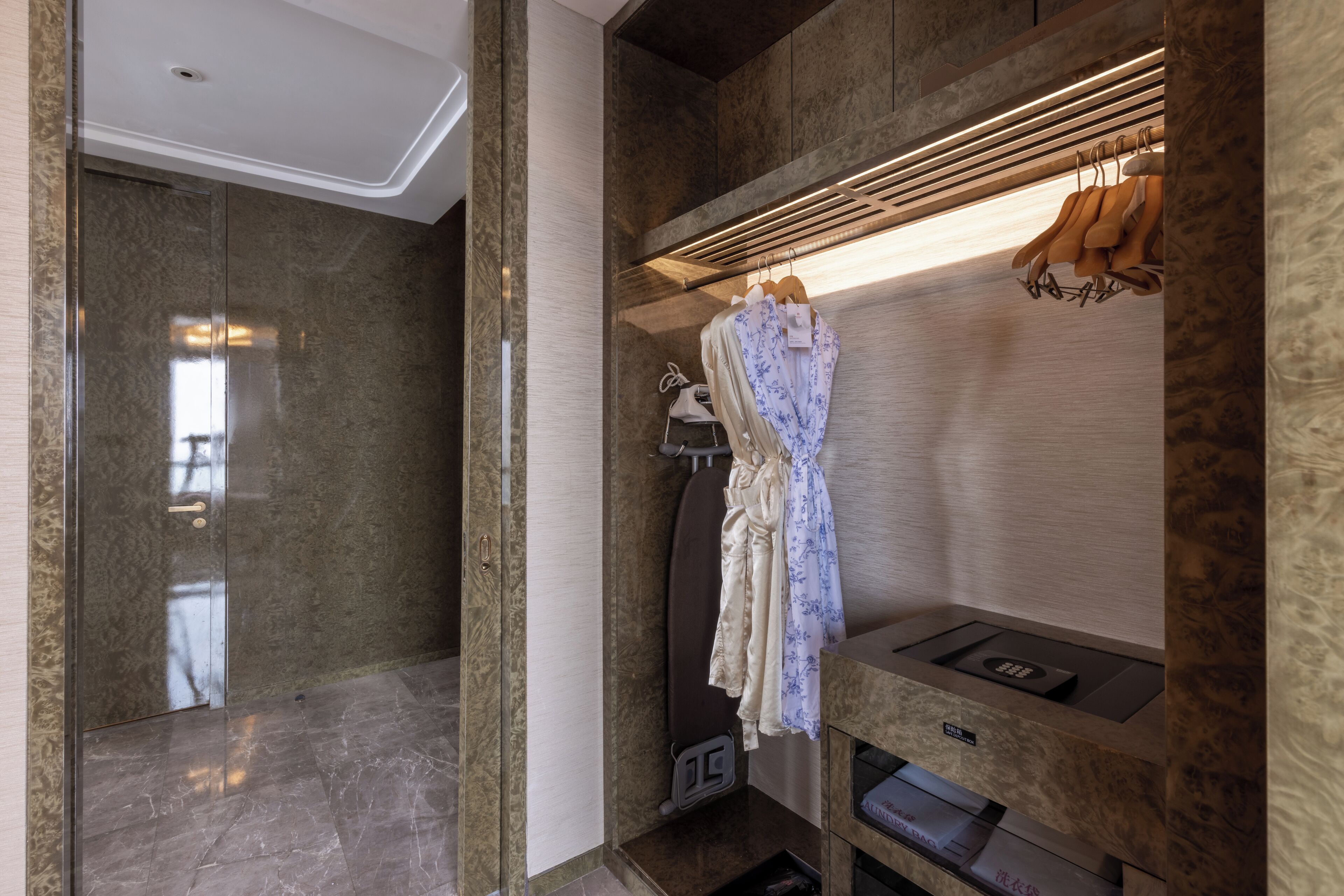 A modern bathroom with a marble floor, a built-in shower, and a vanity with a mirror and towel rack.