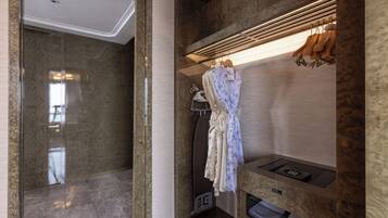 A modern bathroom with a marble floor, a built-in shower, and a vanity with a mirror and towel rack.