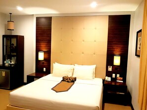 A hotel room with a large bed, two bedside tables, a wardrobe, and a mirror. - D' Hotel and Suites (Dipolog)