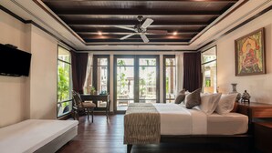A bedroom with a bed, a bench, a desk, and a television. - Jantra Residence by Chinocollection (Kathu)