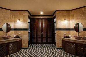 A modern bathroom with two sinks, large mirrors, and a patterned floor.