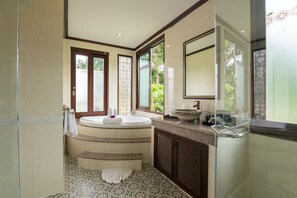A modern bathroom with a freestanding bathtub, a large mirror, and a vanity with a bowl sink.
