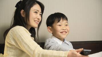 A woman and a child sitting at a table with a smartphone.