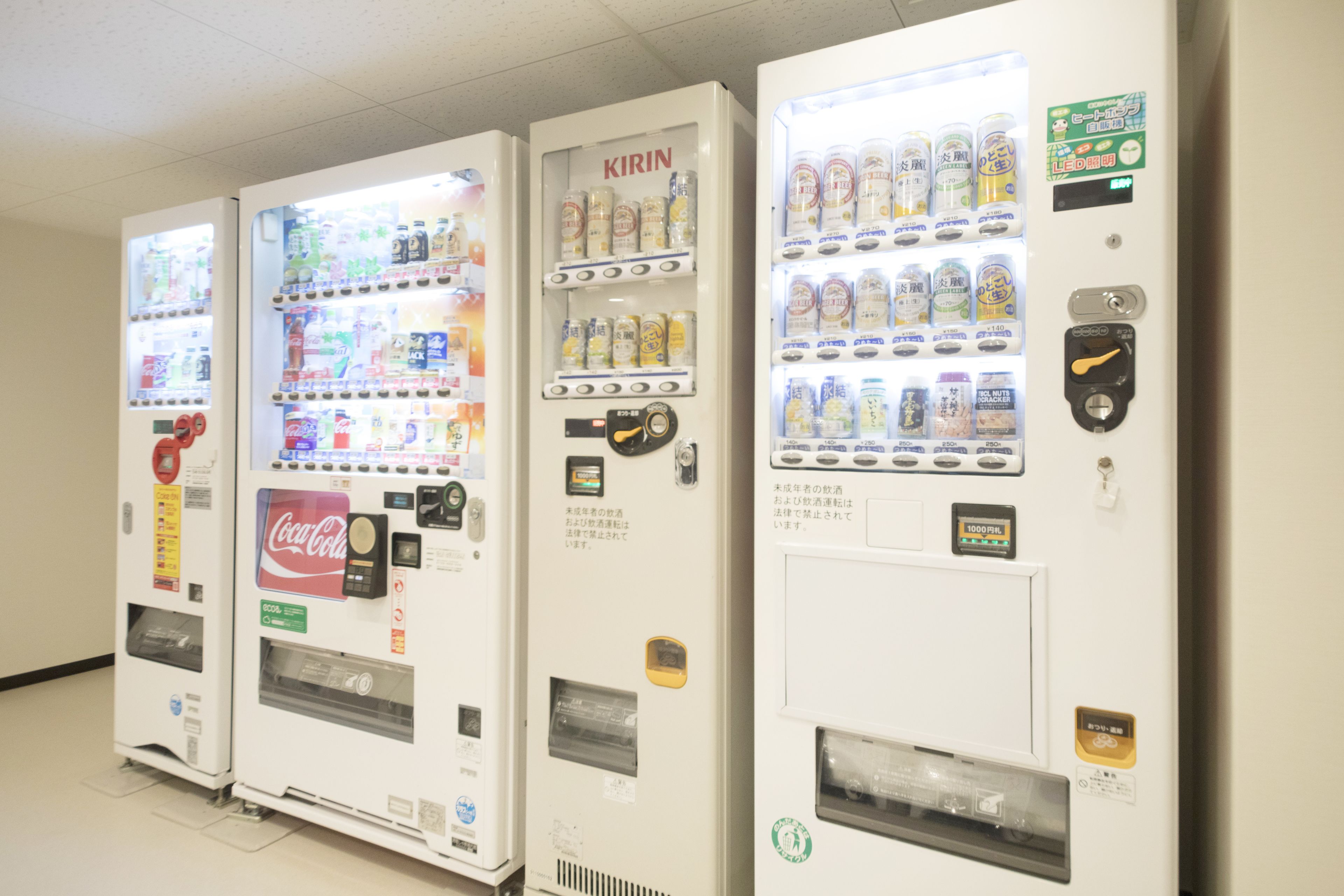 Four vending machines with various beverages and snacks.