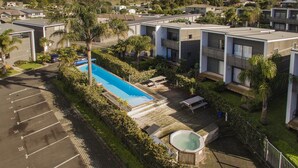 A residential complex with modern buildings, a swimming pool, and a hot tub.