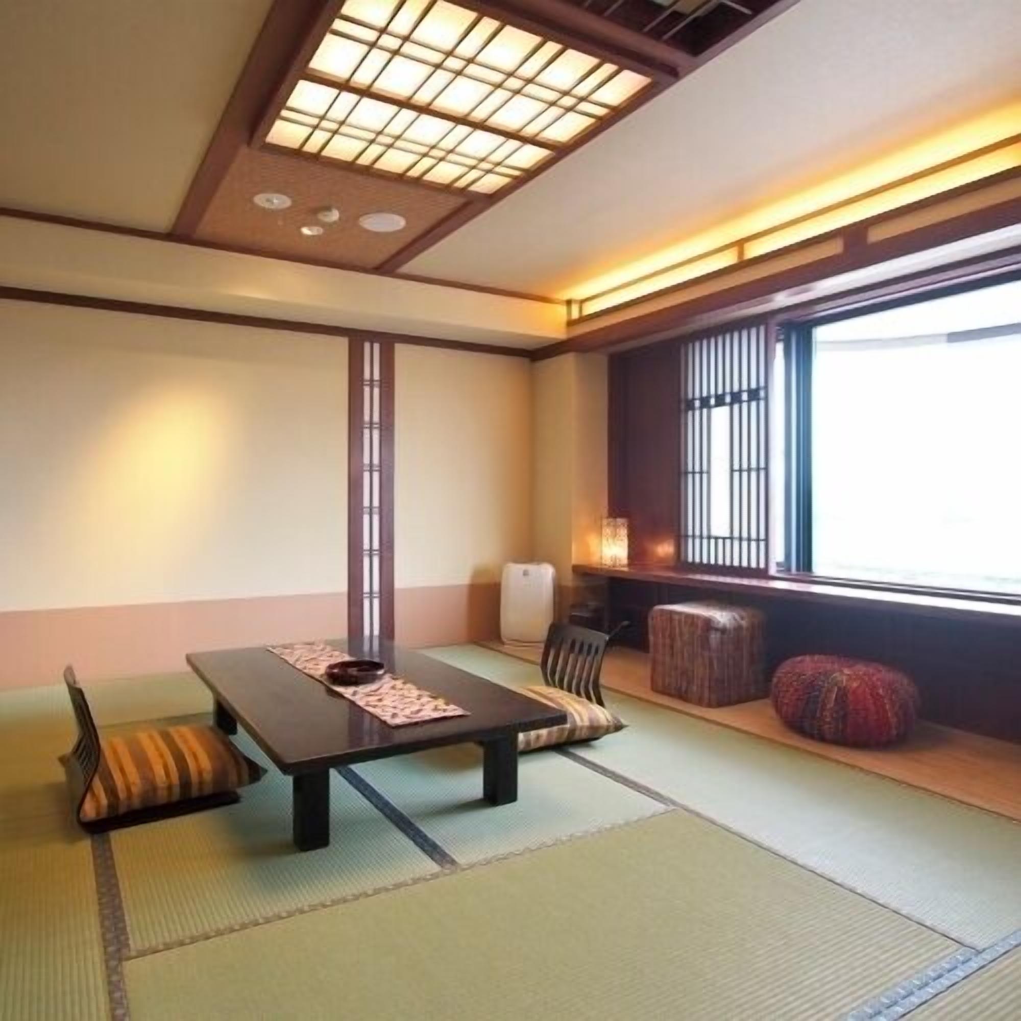 A traditional Japanese room with tatami flooring, a low table, cushions, and a sliding door.