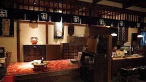 En traditionell japansk restaurang med tatamimattor på golvet, låga trädiskar och en varm och inbjudande atmosfär.
