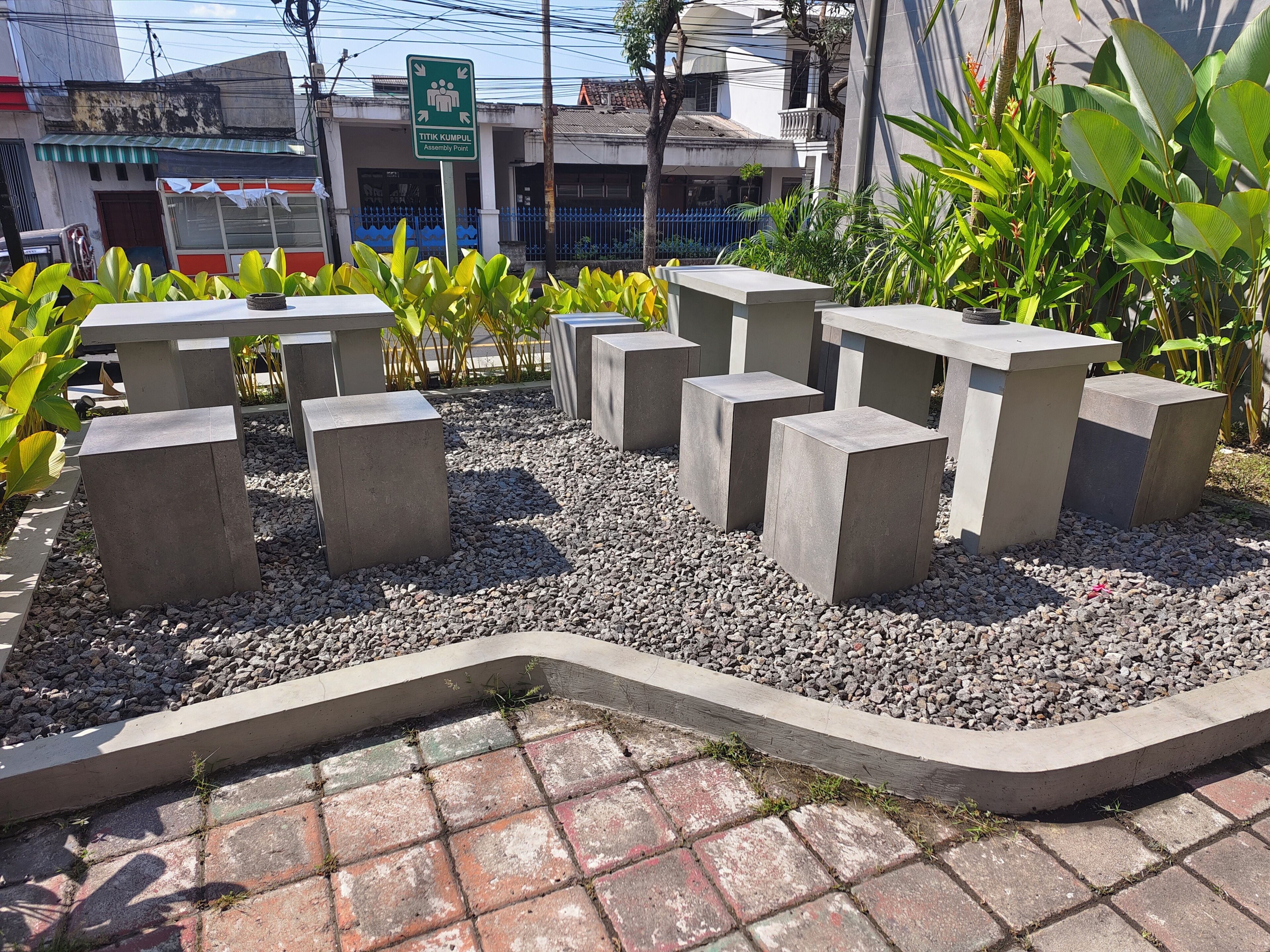 Un jardín con macetas de hormigón y un camino pavimentado.